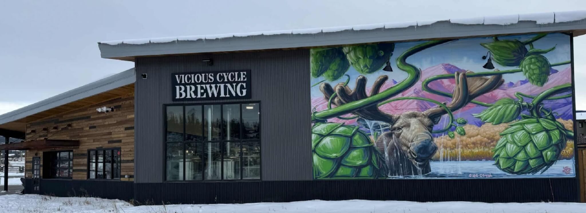A brewery building with a mural of a moose and hops on its side in Grand County Colorado.