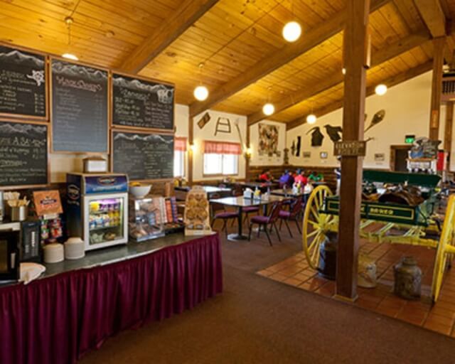 Rustic cafe interior with wooden beams, chalkboard menus, and vintage wagon wheel decor in Grand County Colorado.