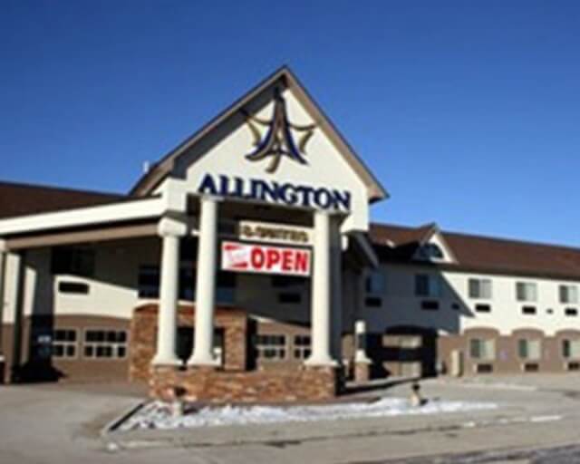 A multi-story hotel with a prominent sign and large windows, featuring a stone and stucco exterior in Grand County Colorado.
