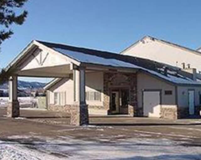 A single-story building with a covered entrance and snow on the ground in Grand County Colorado.