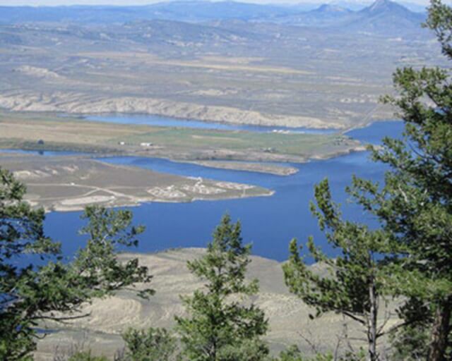 Aerial view of a serene lake surrounded by mountains and evergreen trees in Grand County Colorado.
