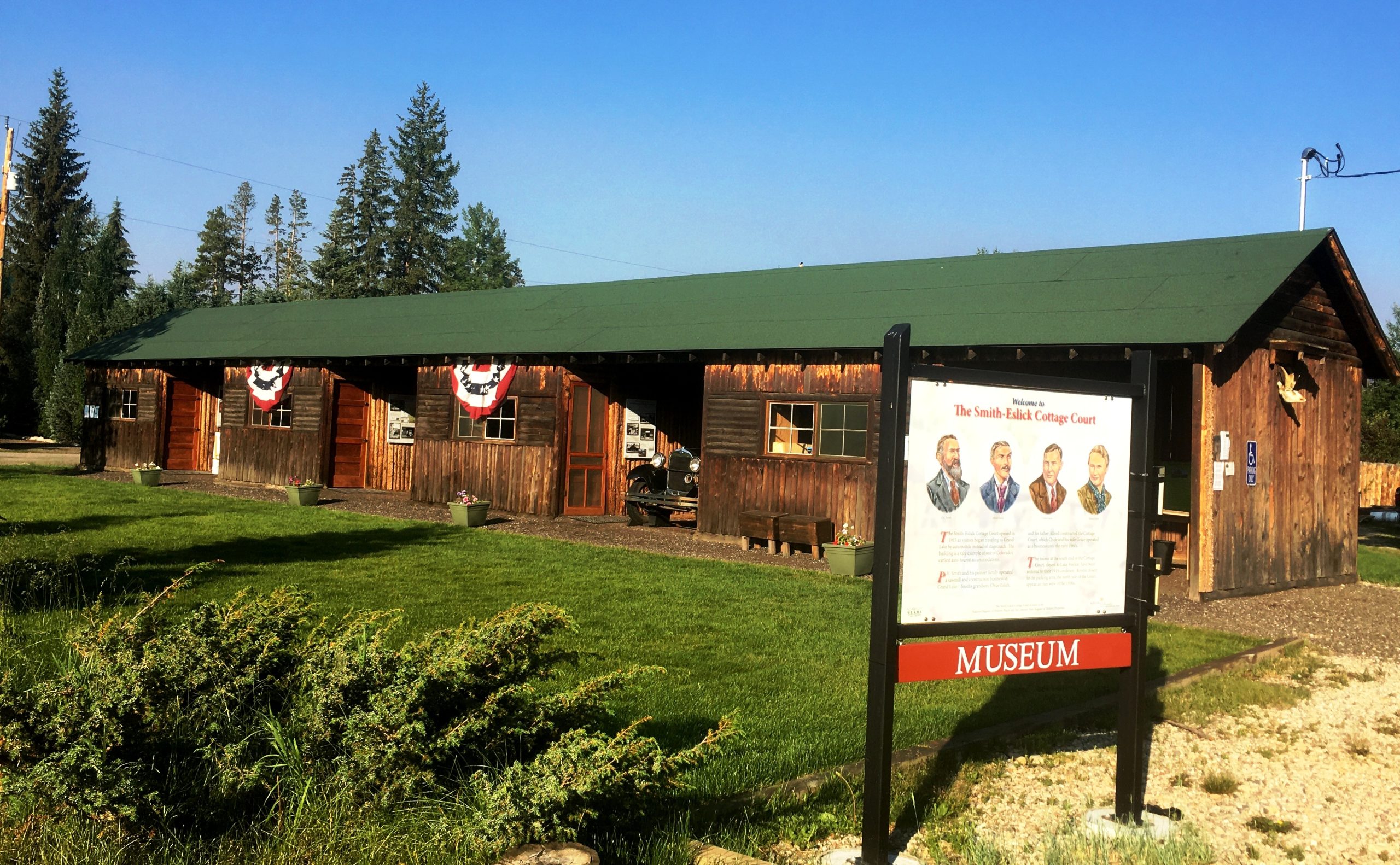Cottage Court Museum with historic sign and wooden building on a sunny day.