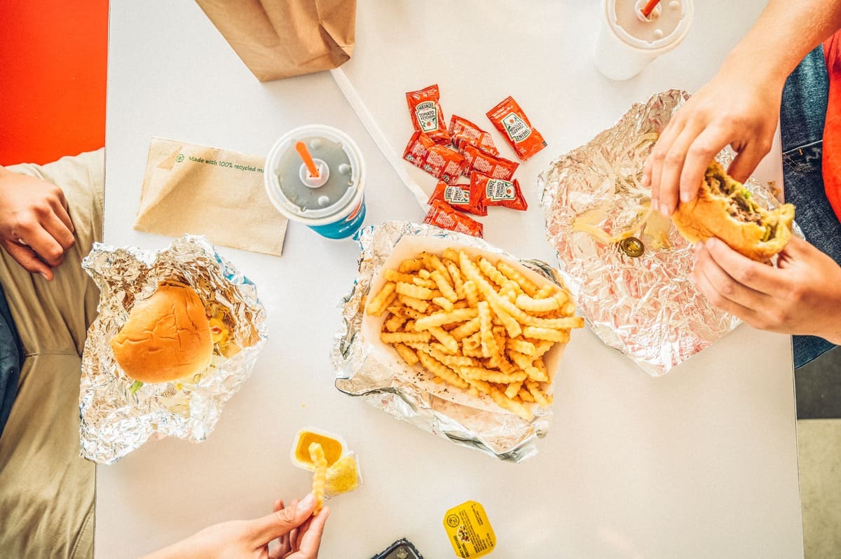 A group of people eating burgers and fries at a table at Debbies Drive In in Granby