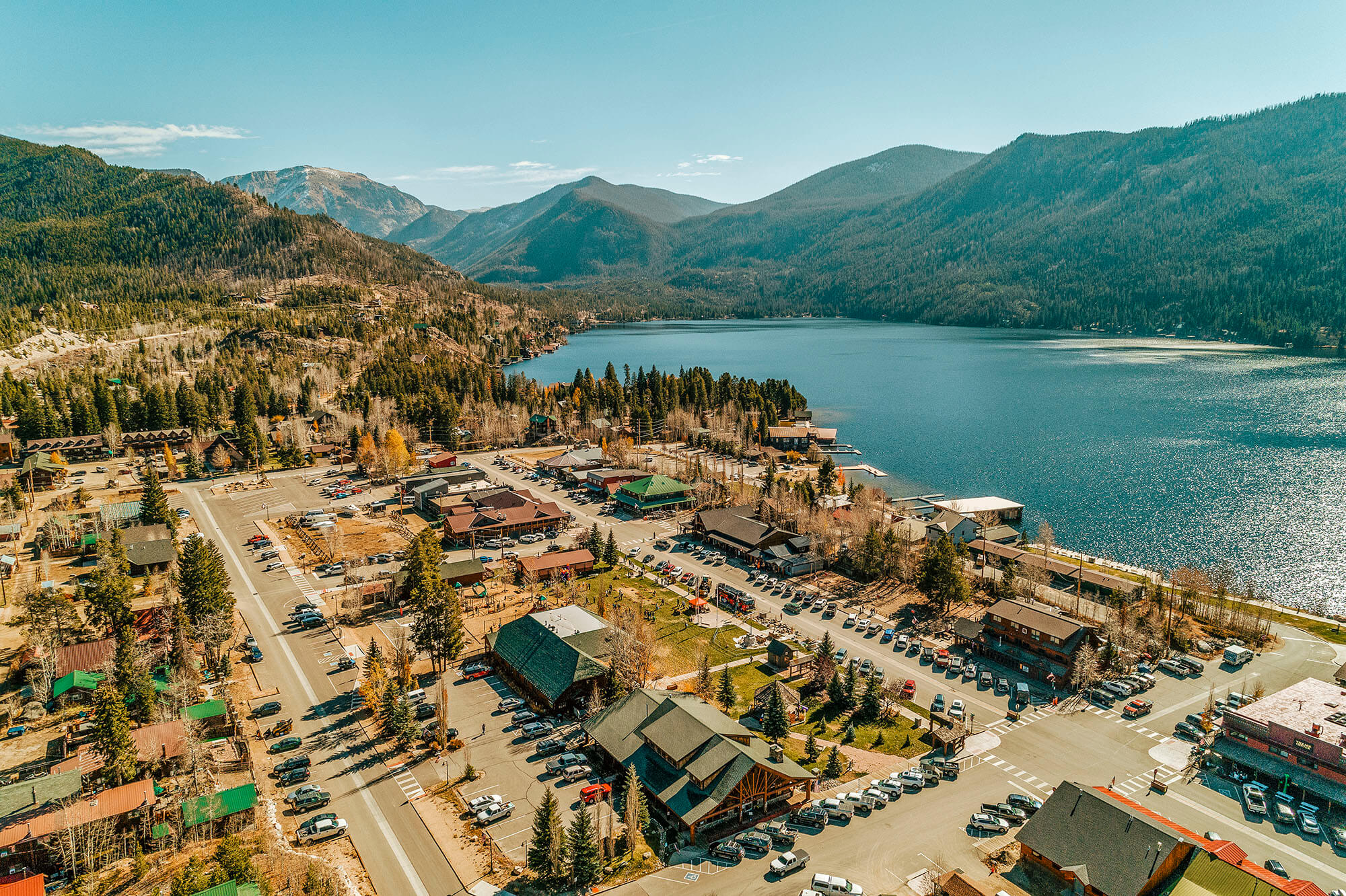 Aerial view of a mountain lake village with colorful buildings and a bustling main street in Grand County Colorado.
