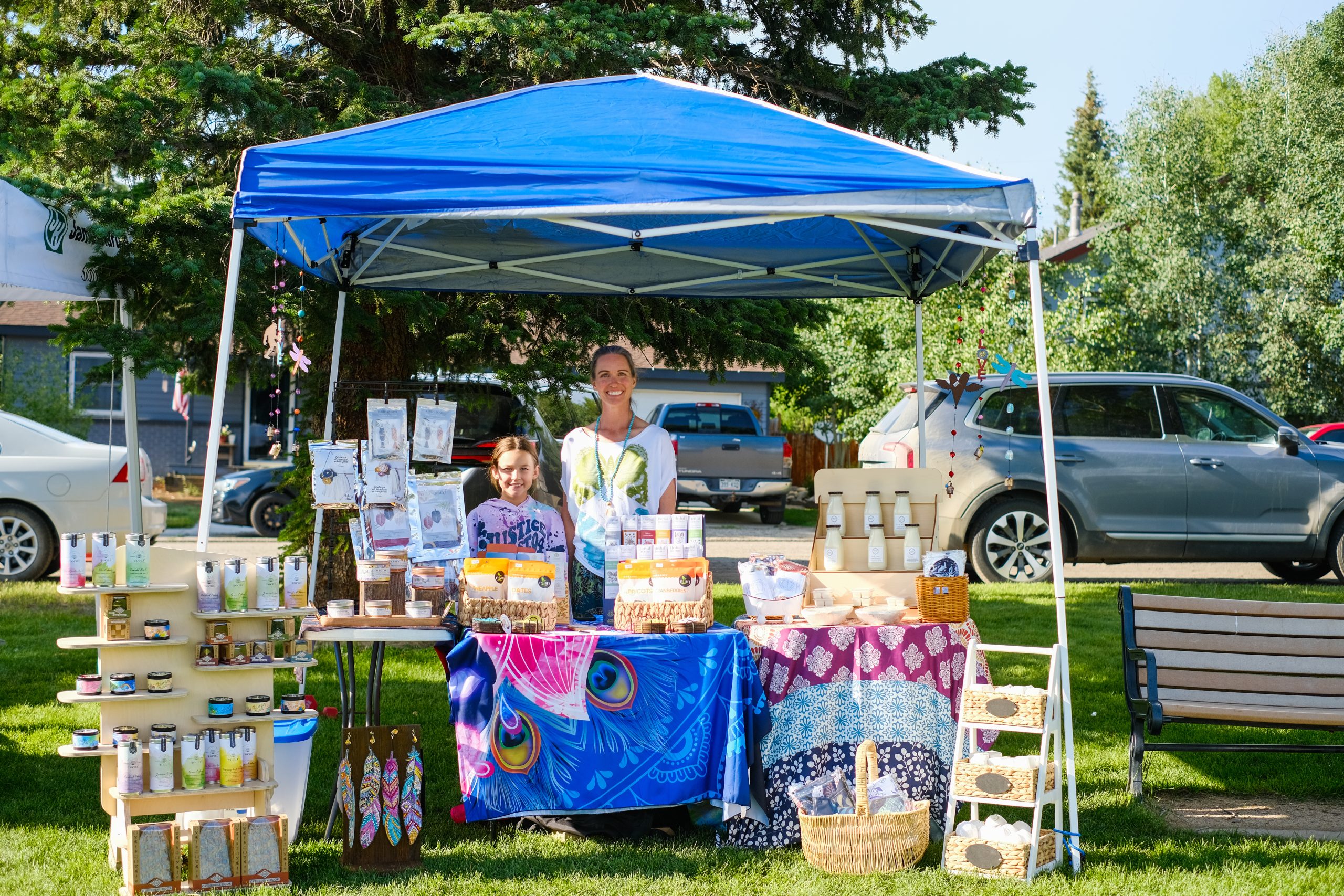 Fresh Colorado local produce including peaches and greens on display at a Grand County farmers market stand.
