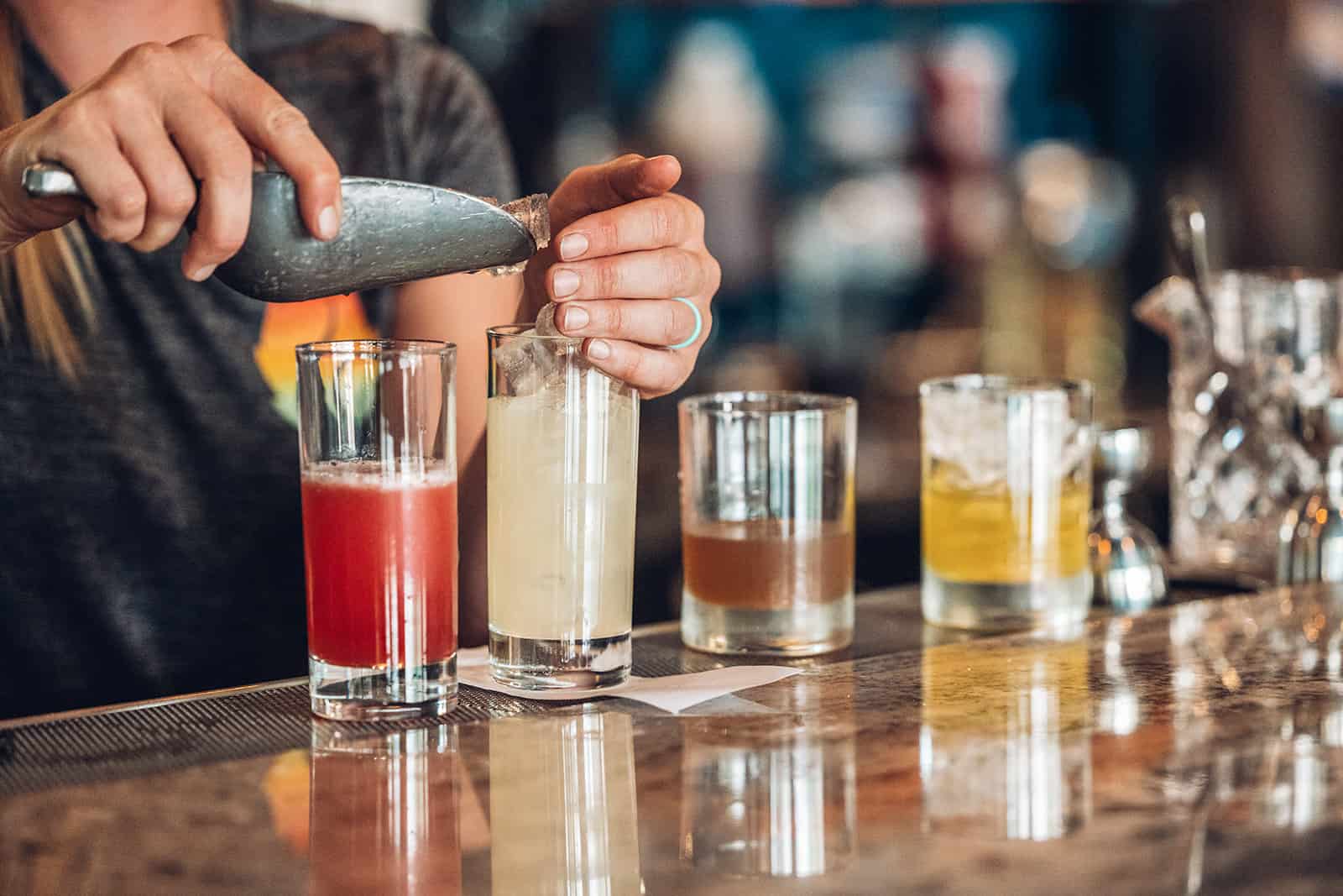 A bartender is making a drink at a bar.