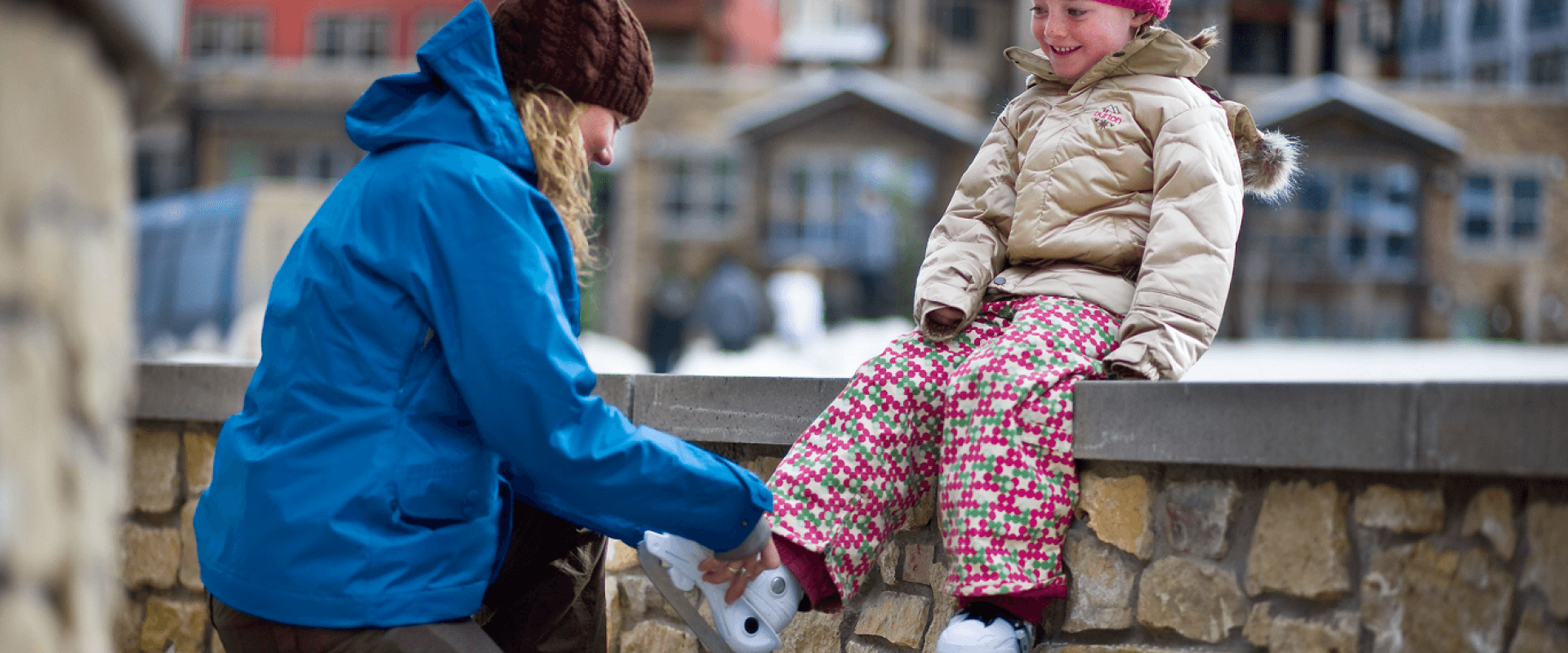 Adult helping a child put on ice skates at the Fraser Valley Sports Complex.
