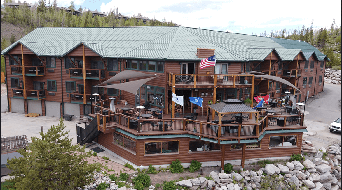 A rustic log cabin resort with multiple balconies and outdoor seating areas in Grand County Colorado.