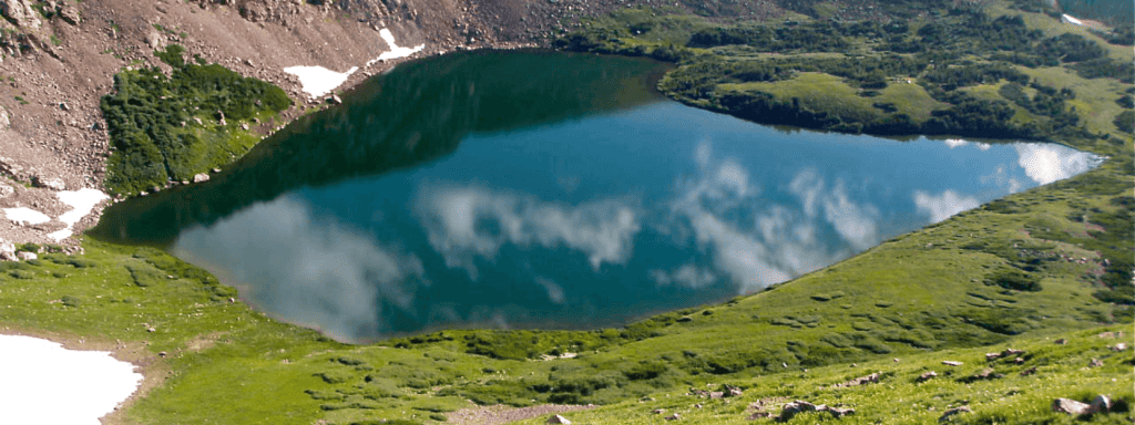 A blue lake in the middle of a mountain.